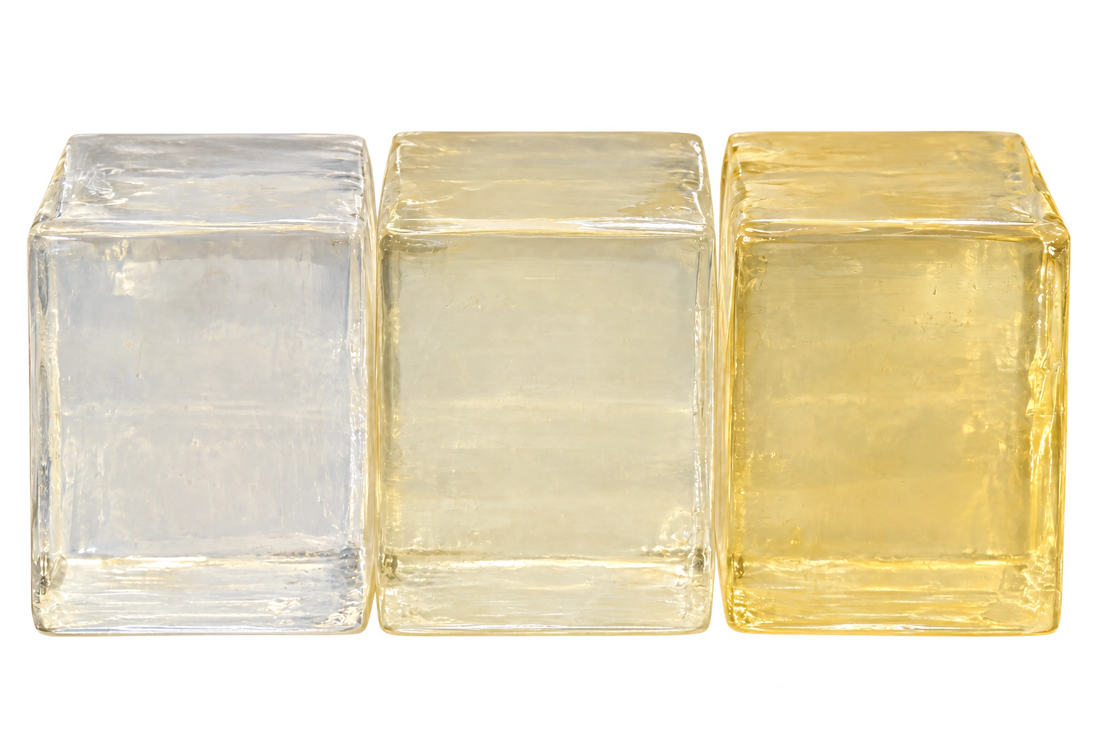 Three translucent hotmelt adhesive blocks from clear to pale amber