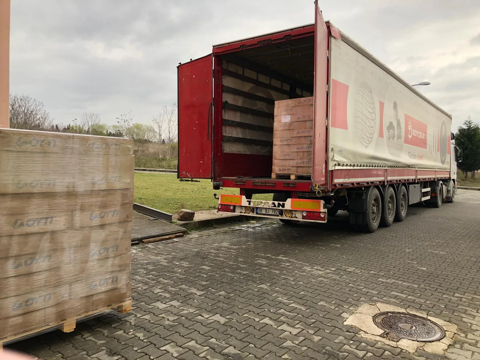 Wrapped pallets of OYTI adhesive cartons being loaded into a truck