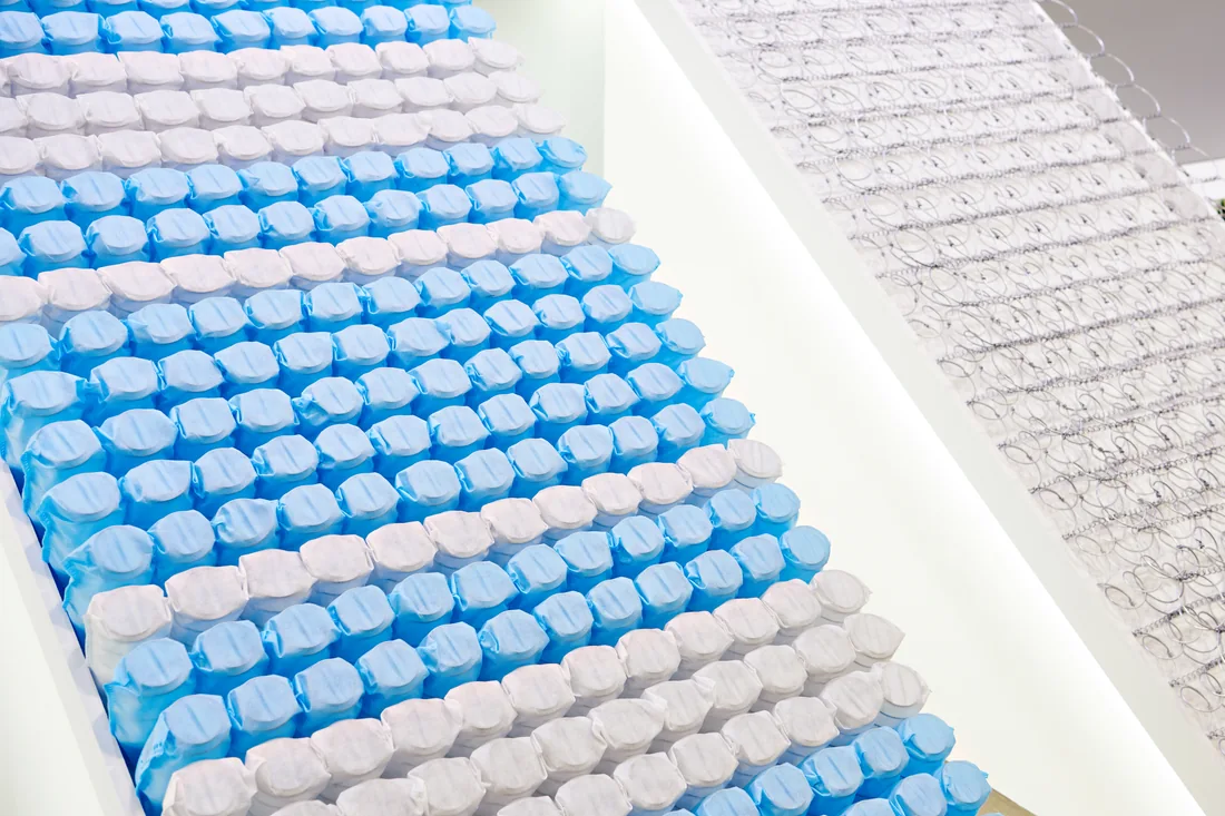 Blue and white pocket-spring units beside an exposed interconnected spring construction