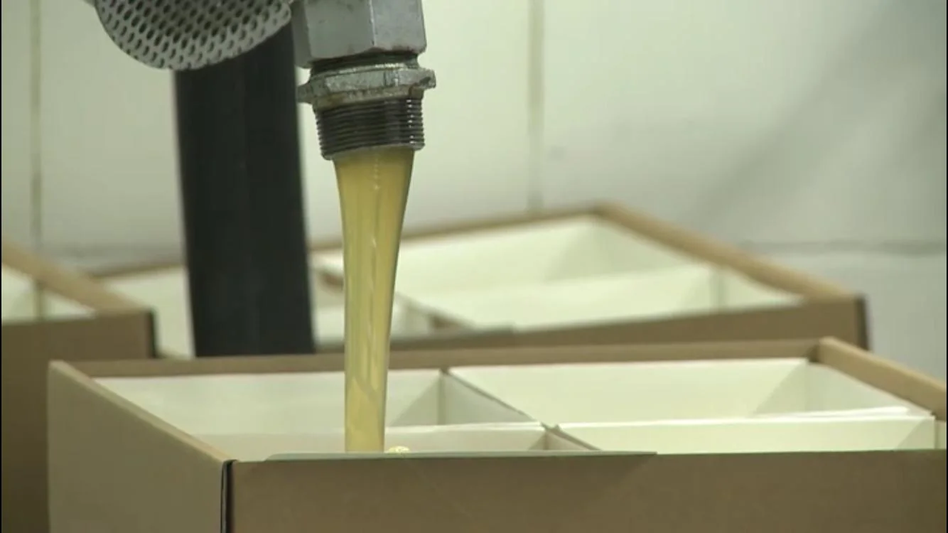 Molten adhesive being filled into lined compartments